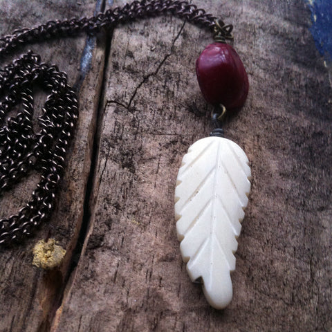 White Carved Bone Feather Bead with red seed pod on copper chain